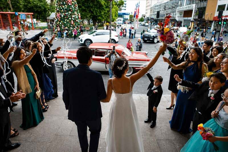 Salida de los recién casados rodeados de invitados celebrando su matrimonio. MatriDron