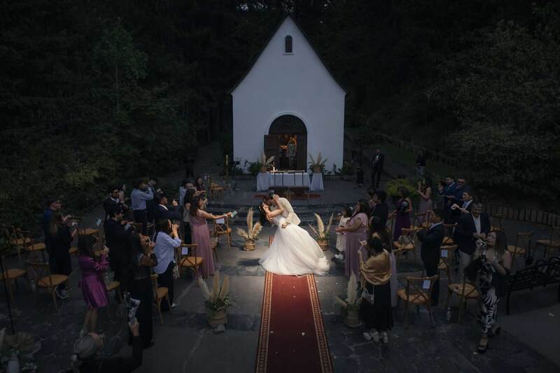 Salida de los recién casados rodeados de invitados celebrando su matrimonio. MatriDron