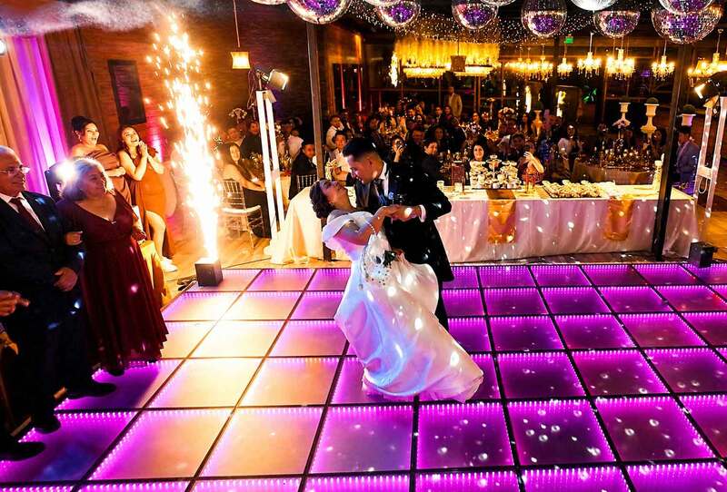 Primer baile de los recién casados en una pista de baile iluminada durante la celebración de su matrimonio. MatriDron