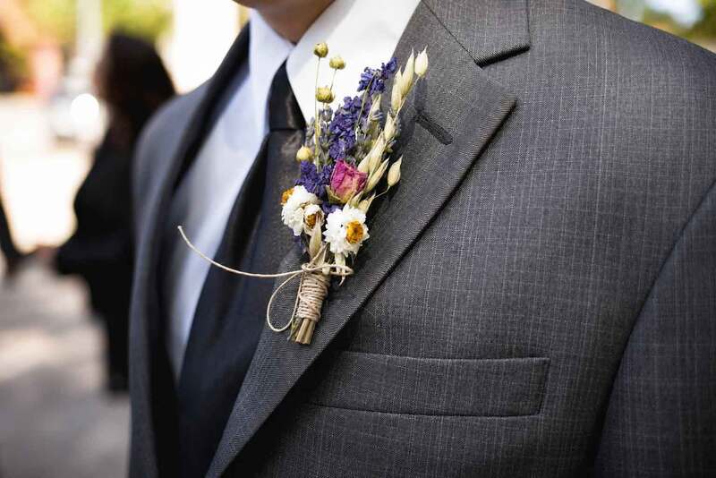 Detalle elegante del traje del novio con flor en la solapa capturado durante sesión de boda.